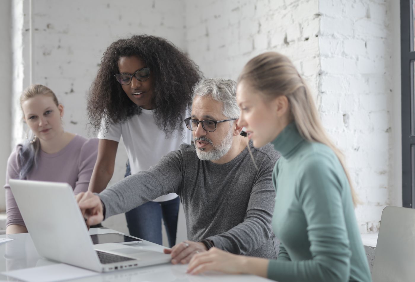 Colleagues learning together around a laptop